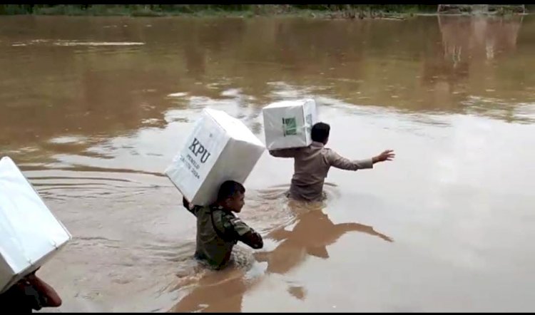 Kawal Kotak Suara Ke TPS, Aipda Marki Pikul Kotak Suara Sebrangi Sungai